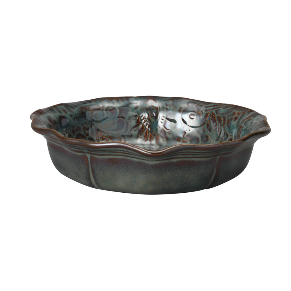 Photo of a small ceramic bowl with fluted edges in a dark glossy fig coloured glaze.