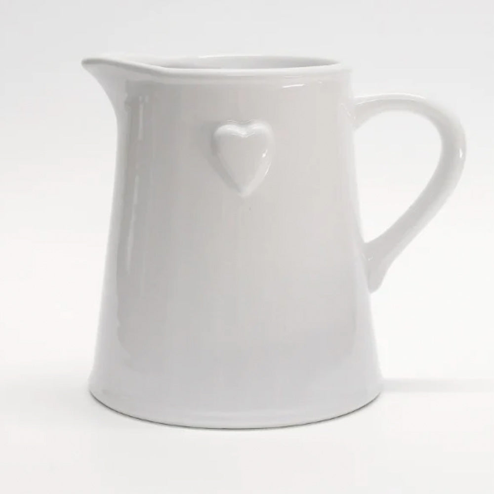 Photo of a white ceramic jug with raised heart detail on the side of the jug.