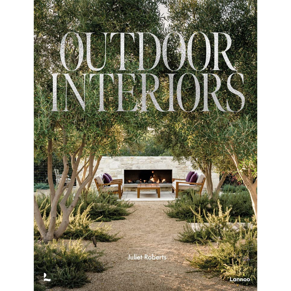 Photo of the cover of Outdoor Interiors hardcover book showing a timber garden seat setting in front of a stone firepace and surrounded by olive trees and ferns.