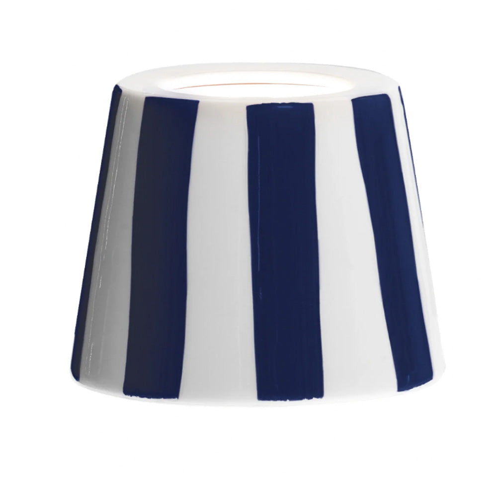 Close up photo of a ceramic lamp shade cover in a glossy blue and white stripe glaze.
