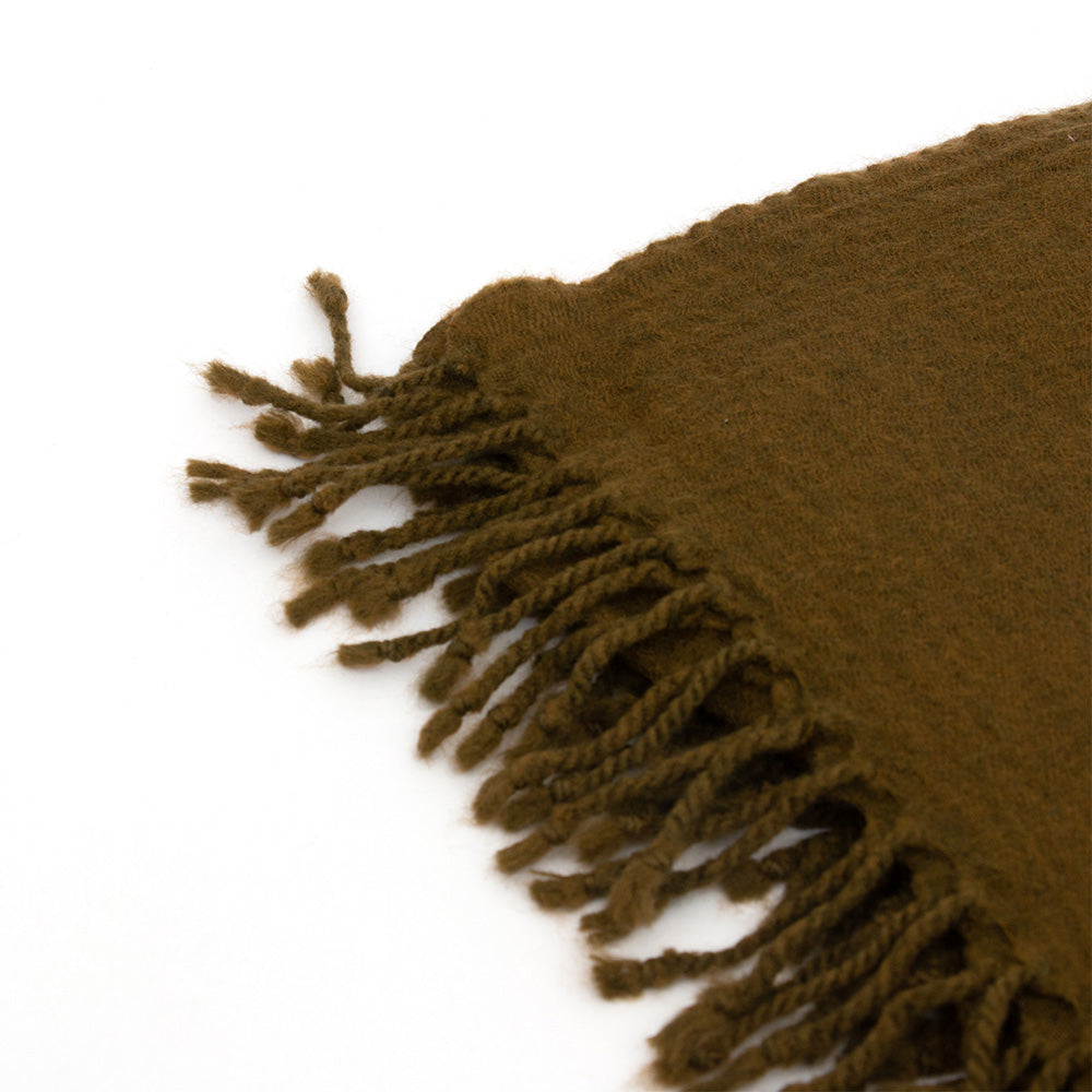 Close up of Olive Woollen Throw blanket showing the fringe detail at the edges.