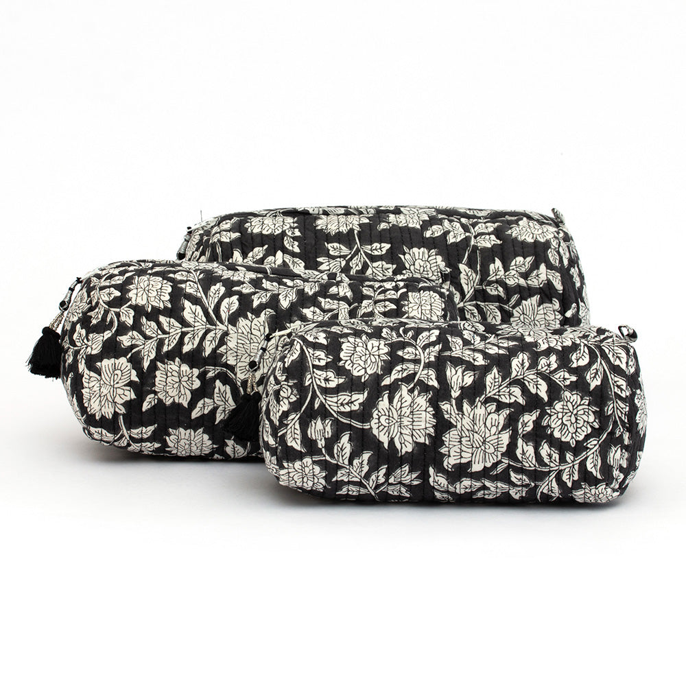 Photo of three blue charcoal floral block printed quilted cosmetic pouches showing the three different size options.