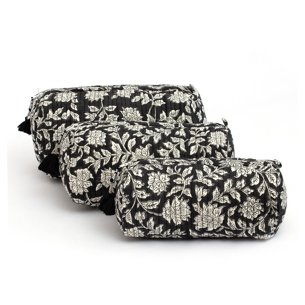 Photo of three blue charcoal floral block printed quilted cosmetic pouches showing the three different size options.