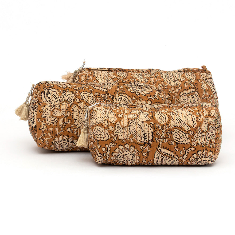 Photo of three coffee spice block printed quilted cosmetic pouches showing the three different size options and the coffee coloured tassel that is attached to the zip.