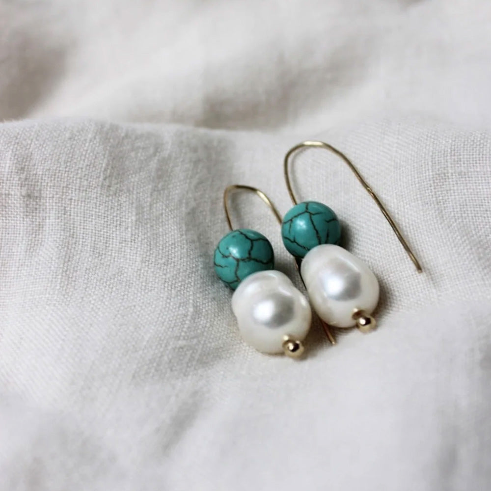 Photo of gold hook earrings with a large teardrop shaped freshwater pearl and a round turquoise coloured agate stone.