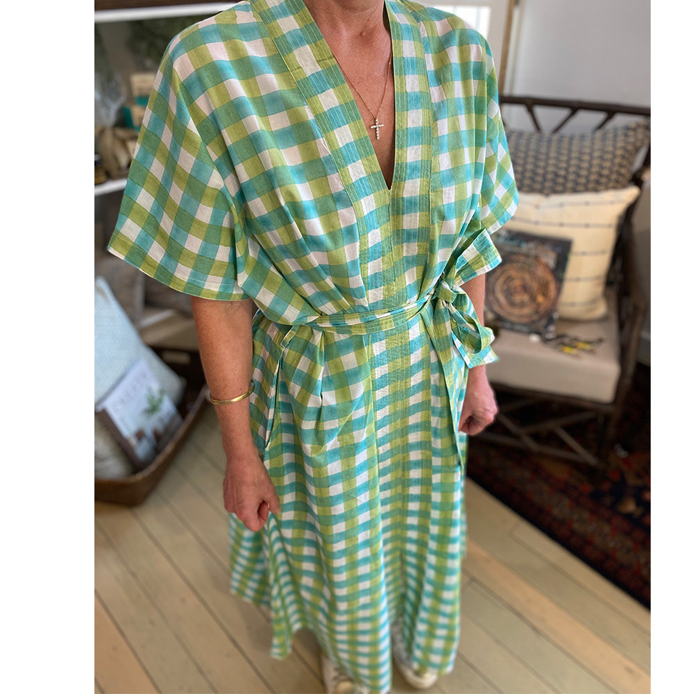 Photo of lady wearing white, aqua blue and mint green check kaftan dress showing the front view of the dress and belt tied to the side.