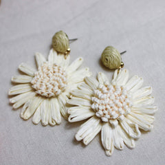 Photo of raffia earrings with a feature raffia daisy in a creamy white colour.