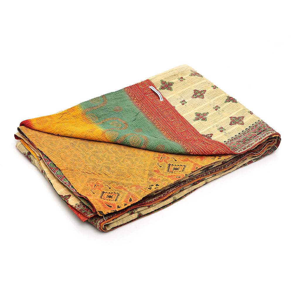 Folded multicoloured vintage kantha quilt with patterns on a white background