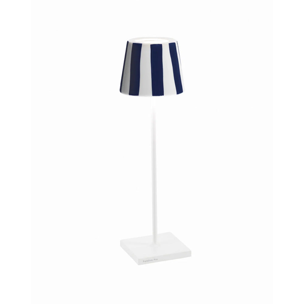 Photo of a white metal battery operated table lamp showing the ceramic lamp shade cover in a glossy blue and white stripe glaze.