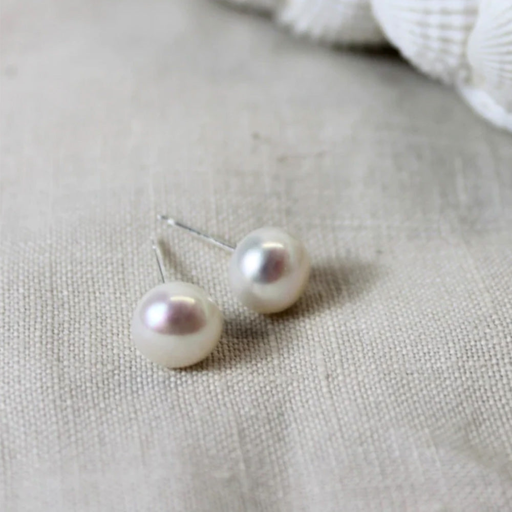 Close up photo of pearl stud earrings on a silver stud bar.
