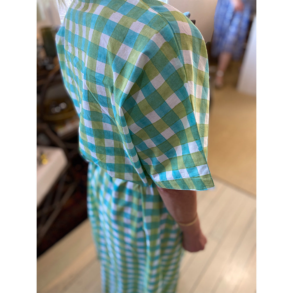 Photo of lady wearing white, aqua blue and mint green check kaftan dress showing the back and side view of the dress.
