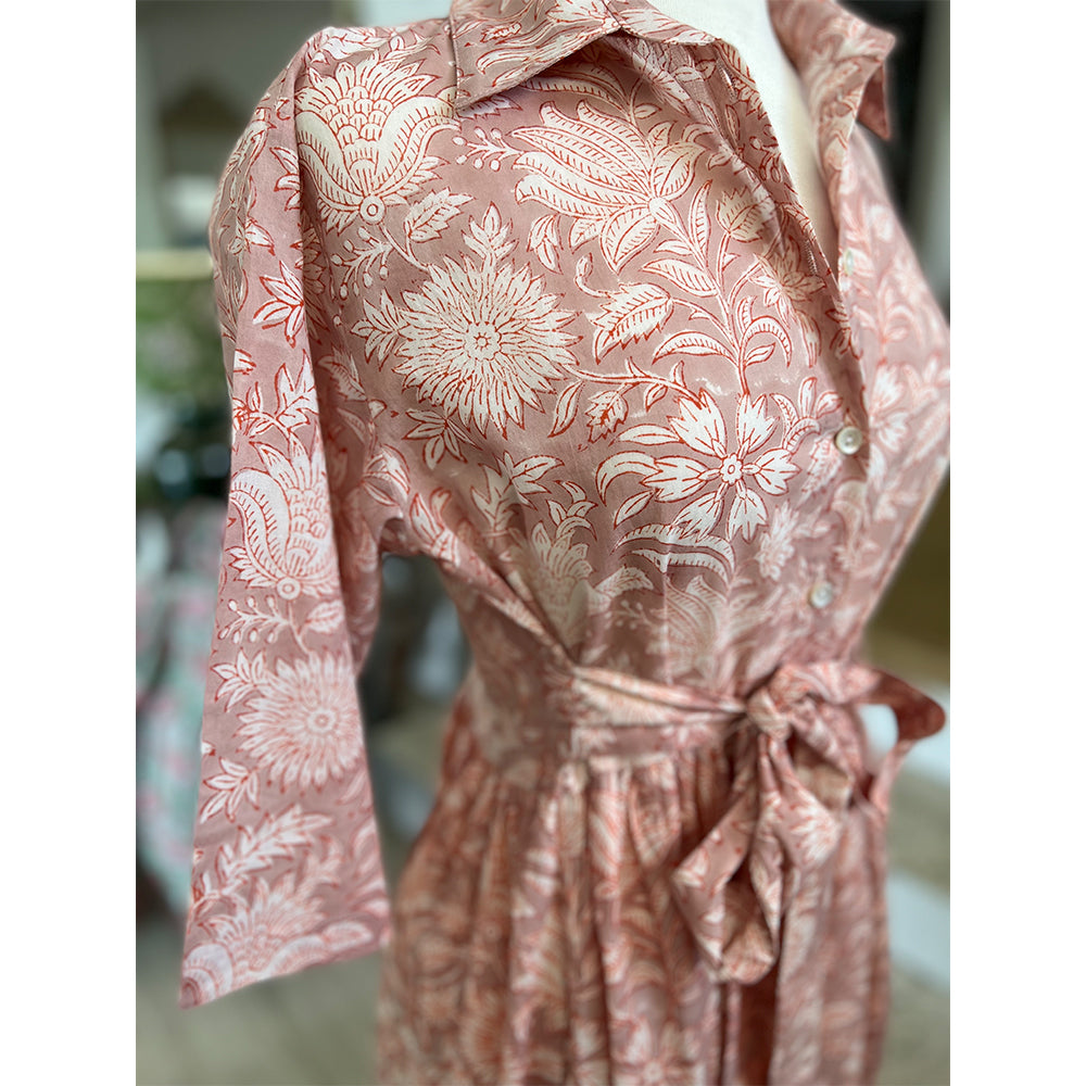 Photo showing fabric detail and pattern on Adaline Dress in coral flower on beige background