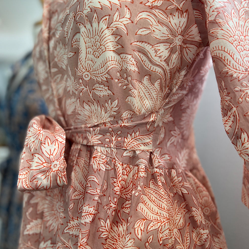 Photo showing fabric detail and pattern on Adaline Dress in coral flower on beige background