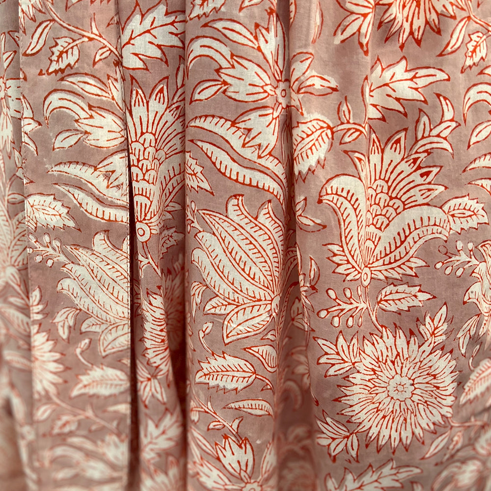 Photo showing fabric detail and pattern on Adaline Dress in coral flower on beige background