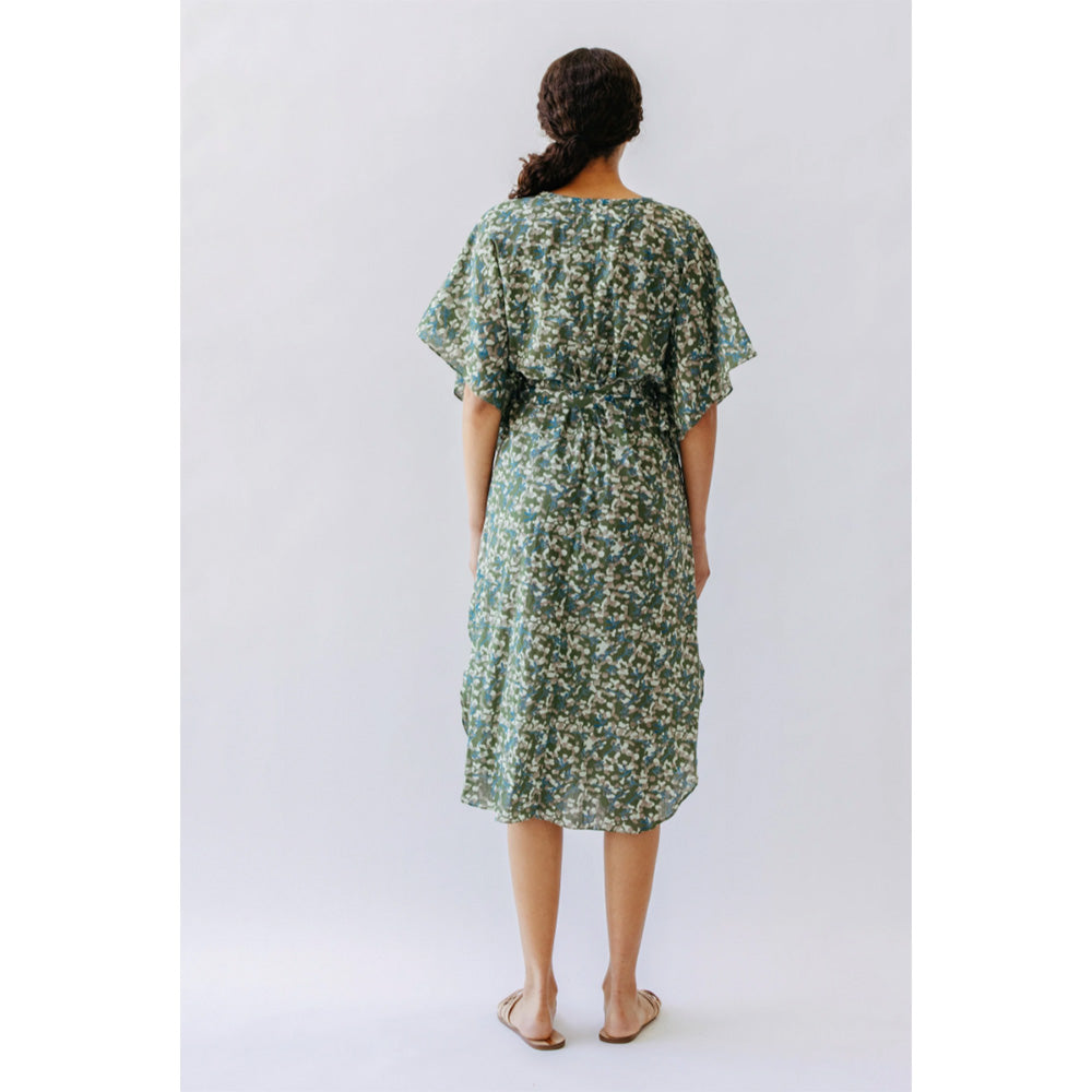 Photo of the back of a model wearing green and yellow spot cotton fabric Bali dress by Mirth