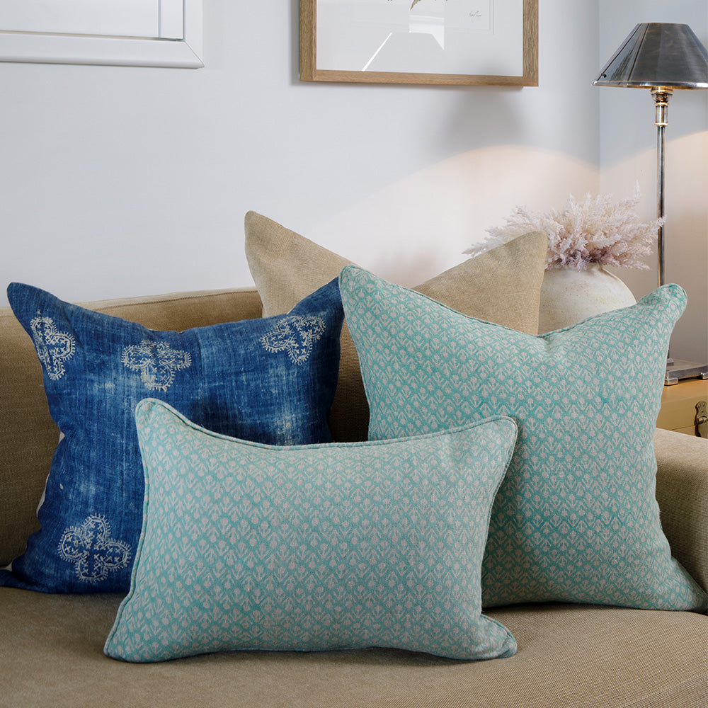 Photo of antique silver metal Bruxelles table lamp sitting on side table in a loungeroom beside a sofa with mint and blue cushions