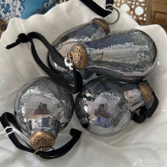 Photo of a collection of antique glass Christmas baubles in a white bowl
