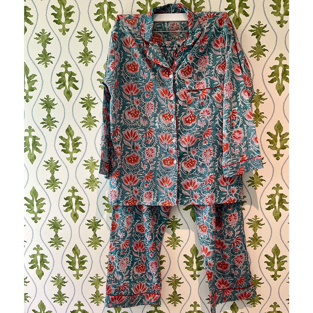 Photo of Augusta coral flower on aqua background cotton pyjamas hanging in front of green floral wallpaper